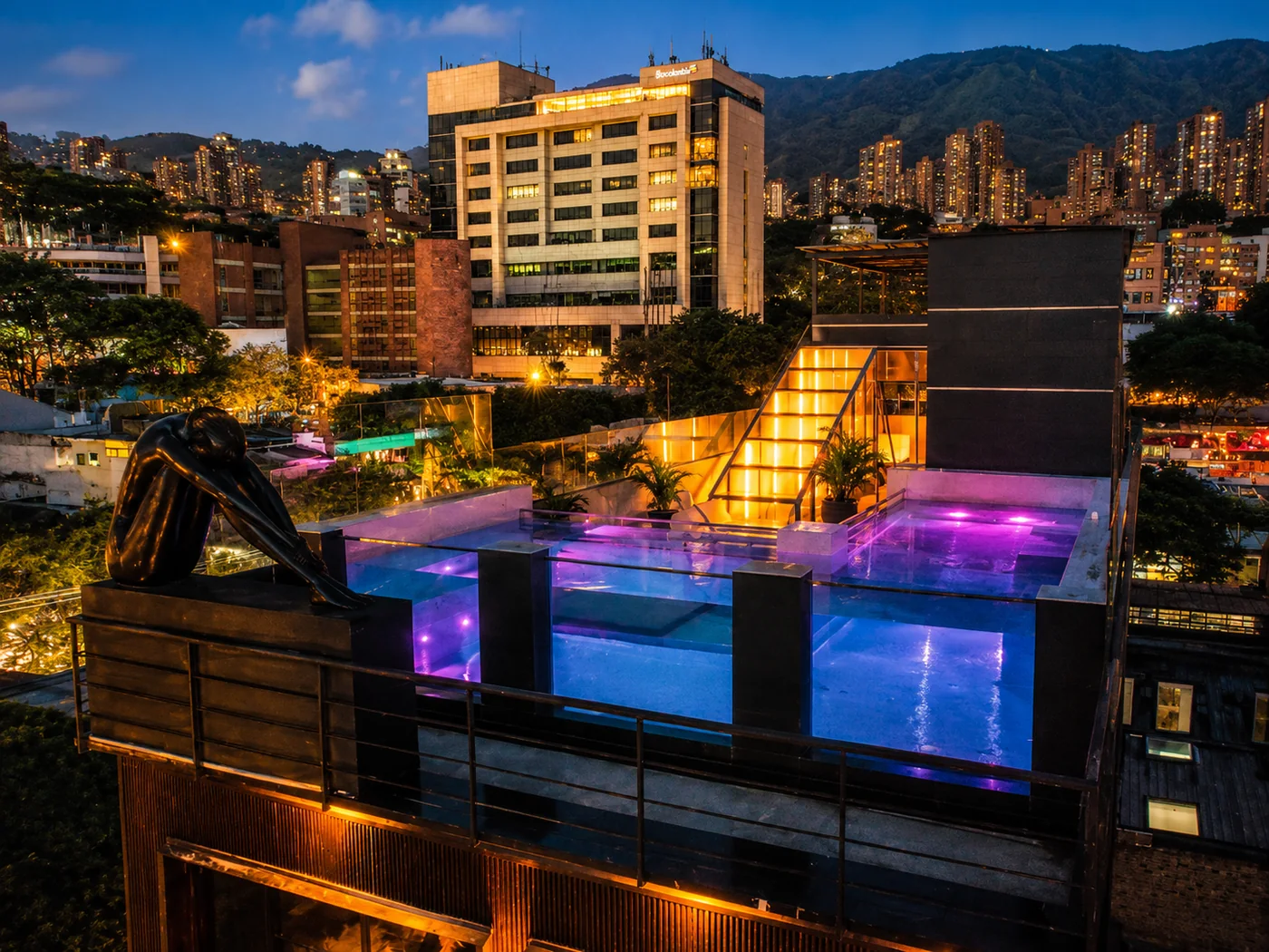 Rooftop Penthouse pool with Medellín skyline at dusk